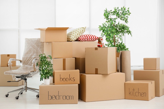 group of stacked and labeled moving boxes in a room
