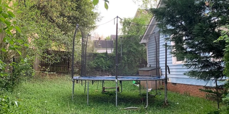 trampoline with enclosure in backyard