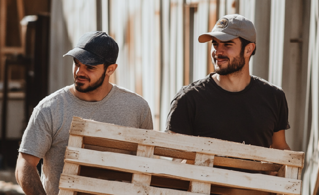 Professionals hauling away a wood pallet