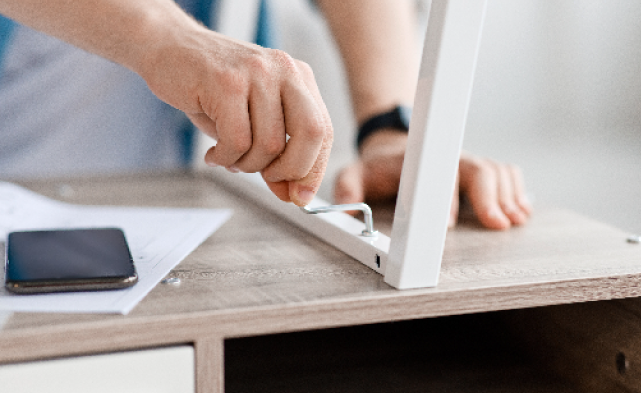 Handy man professionally assemblying a table