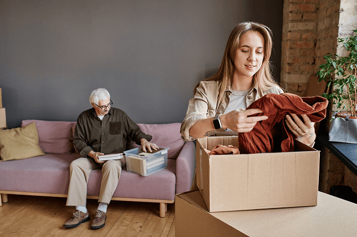 Young woman helping an elderly grandparent downsize their home