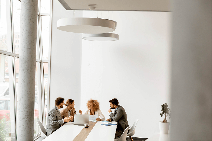 Office employees at a table in an office space discussing sustainability efforts