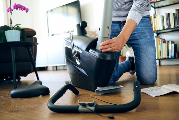 Assembly professional assembling a piece of exercise equipment for a happy customer