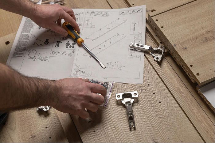Professional assembly technician looking at instruction manual, building furniture for a customer 