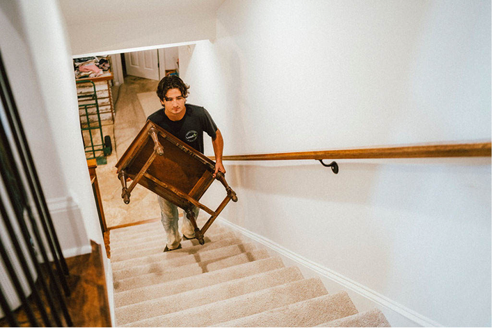 A Loader carrying furniture out of a customer's basement